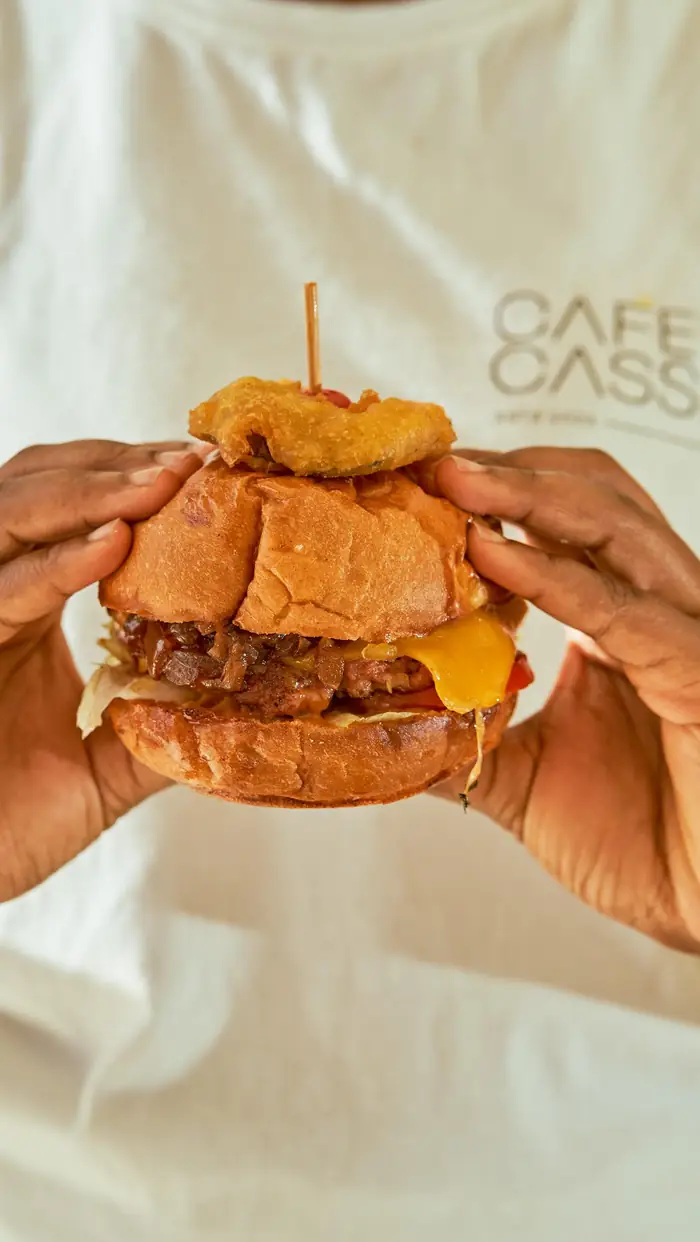 Two hands holding a Cafe Cassia burger